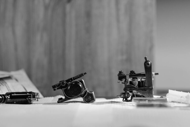 Black and white photo of vintage tattoo machines on a table, ideal for artistic and vintage themes.